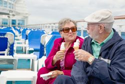 Adult Couple Enjoying Ice Cream On The Deck of a Luxury Passenger Cruise Ship.