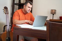 portrait of a happy man with his guitar looking to start online guitar lessons