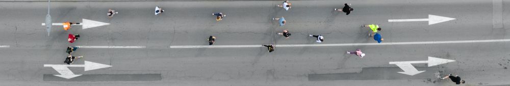 Aerial photo of a group of people running in one direction together.