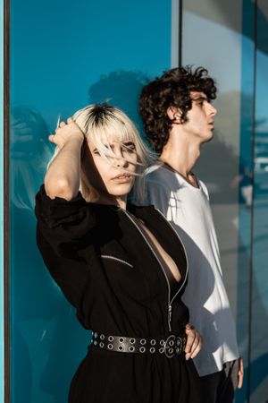 Charming sensual lady and calm guy against blue glossy wall