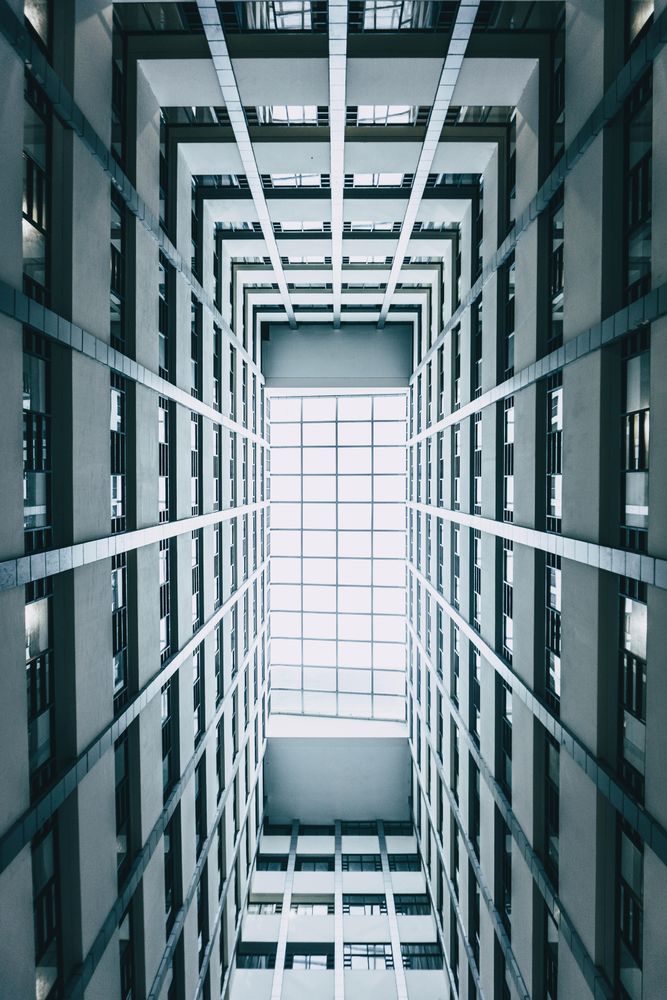 Low angle photo of glass ceiling inside high-rise building