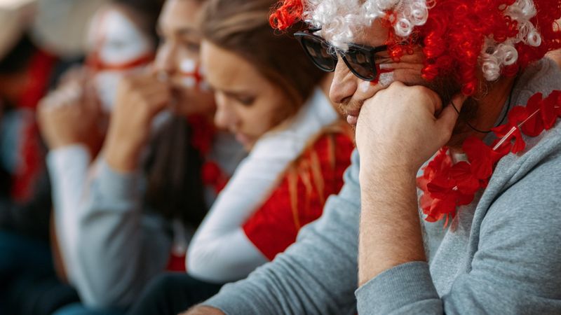 English fans upset about defeat of football team, watching a match live at stadium