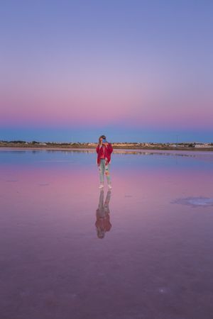Woman taking picture with camera on empty beach