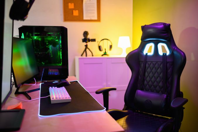 Room with computer monitor gaming PC video camera and headphones with empty chair