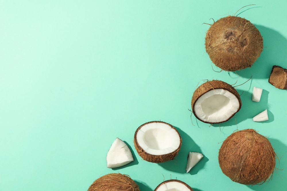 Flat lay with coconut on mint background, top view