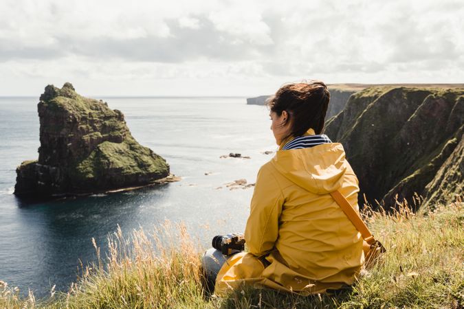 Serene tourist enjoying view of tranquil green valley in cloudy weather
