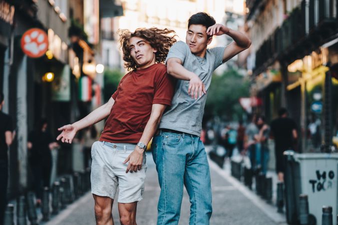 Courageous multiethnic male friends jumping and having fun on street