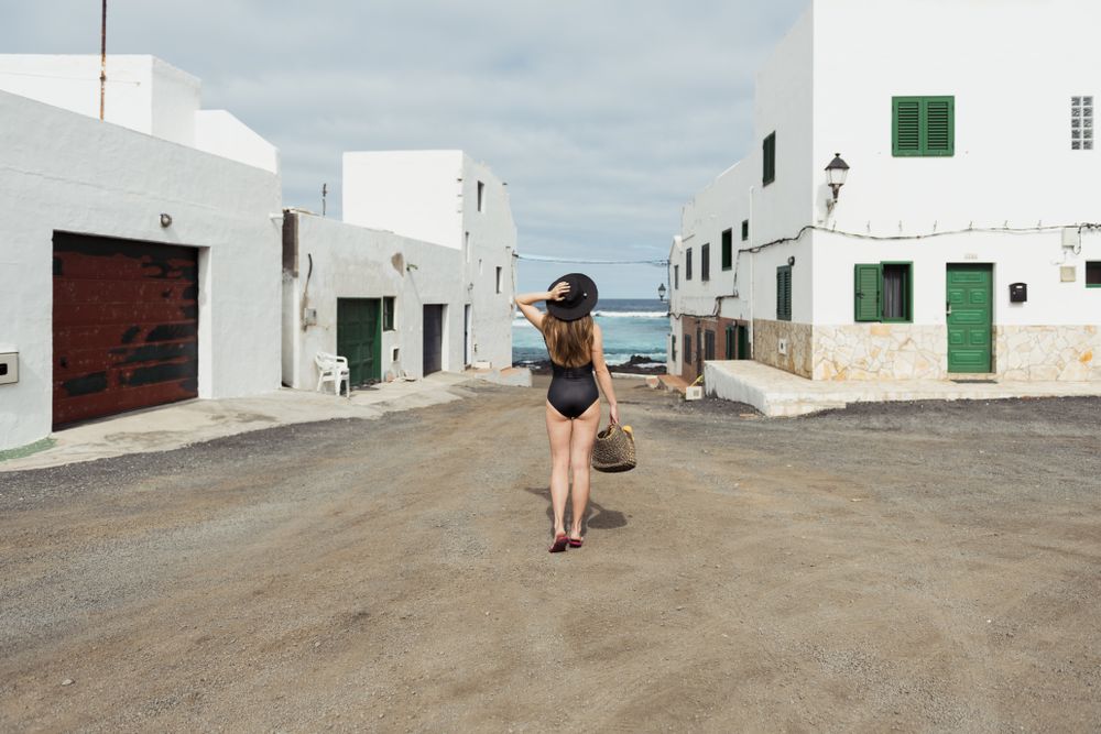 Anonymous female on small street of coastal town