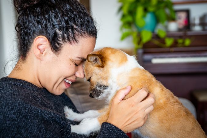 Woman smiling and face to face with cute small dog