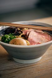 Ramen soup with tasty meat and vegetables in bowl