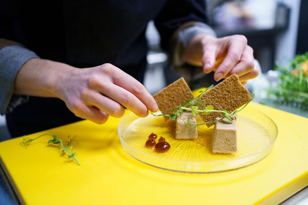 Hands playing biscuits onto decorative plate