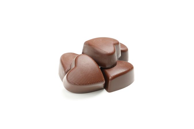 Tasty chocolate candies in the heart form isolated on studio background