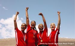 Professional female soccer players celebrating a victory on a sports arena 49lAv5