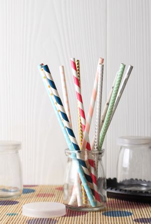 Colorful paper straws on wooden background