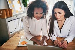 Two women working together at a laptop