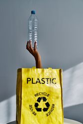 Woman reaching hand with plastic bottle from bag