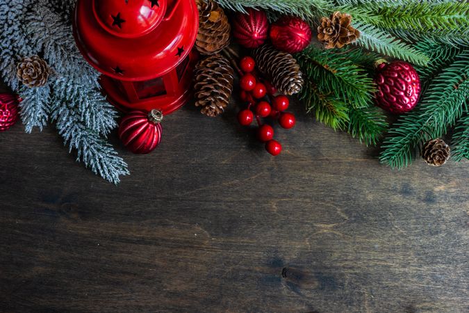 Top view of Christmas setting with pine branches and holly on wooden table