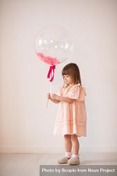 Studio shot of girl in pink dress holding standing 0WJJ6b