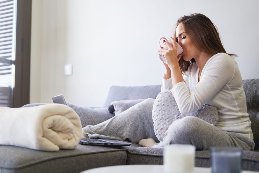 Woman drinking from cup in kitchen