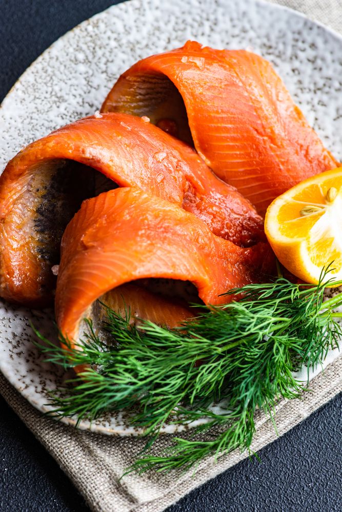 Raw herring fish on plate served with dill and lemon