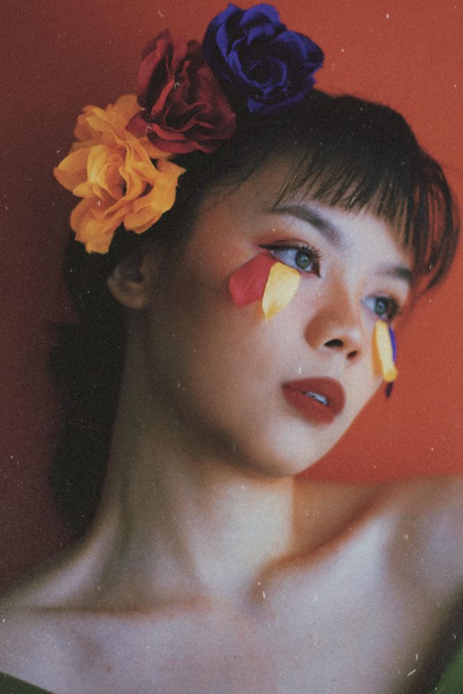 Portrait of woman with colorful roses on her heard with petal flower eyelashes
