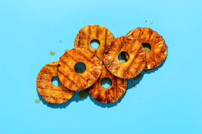 Grilled pineapple with rum sauce, minimalist on a blue background