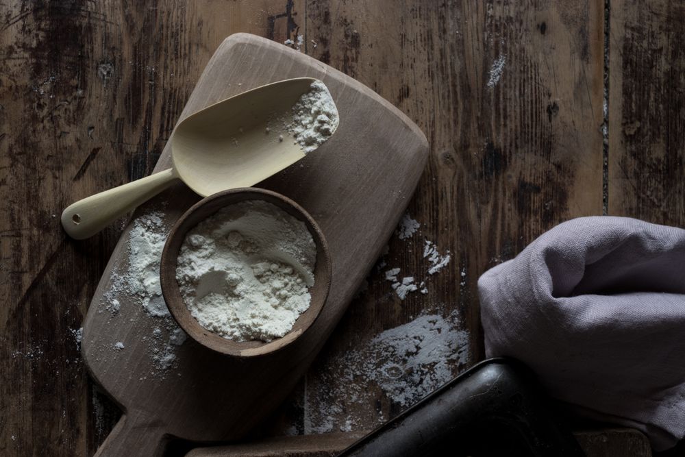 Flour and cooking utensils on wooden table