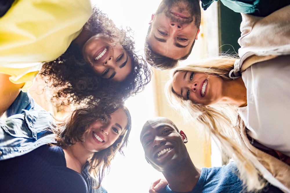Smiling multi-ethnic friends looking down at camera