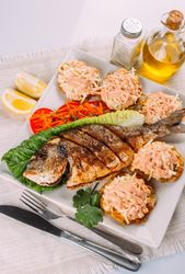 Top view of fried fish, salad and fried plantain