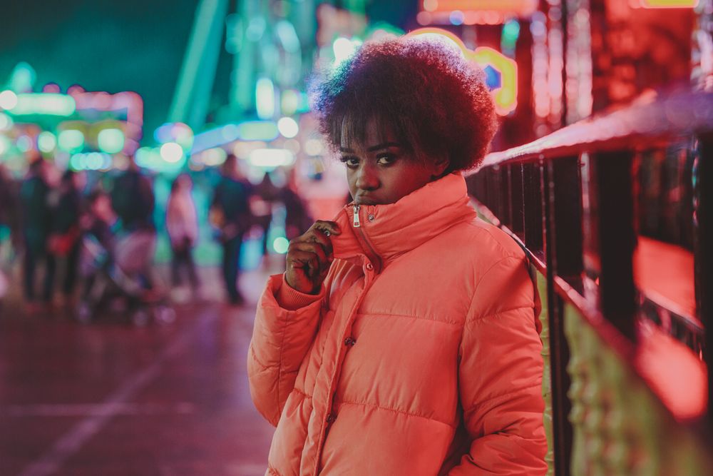 Black female standing near attraction in amusement park