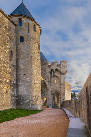 A castle with a tower and a wall. Tower de la Poudre in castle fortification of Carcassonne