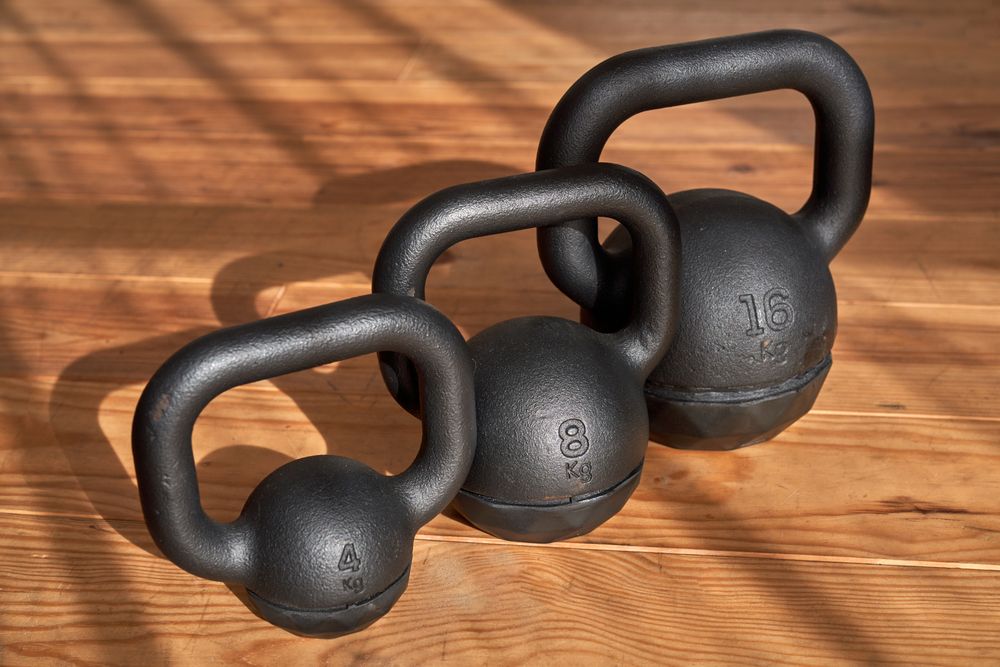 Metal kettlebells placed on wooden floor