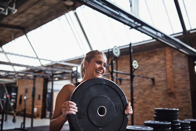 Smiling woman with barbell weights