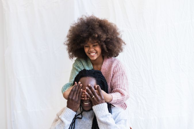 Black girl playing game with father and laughing happily