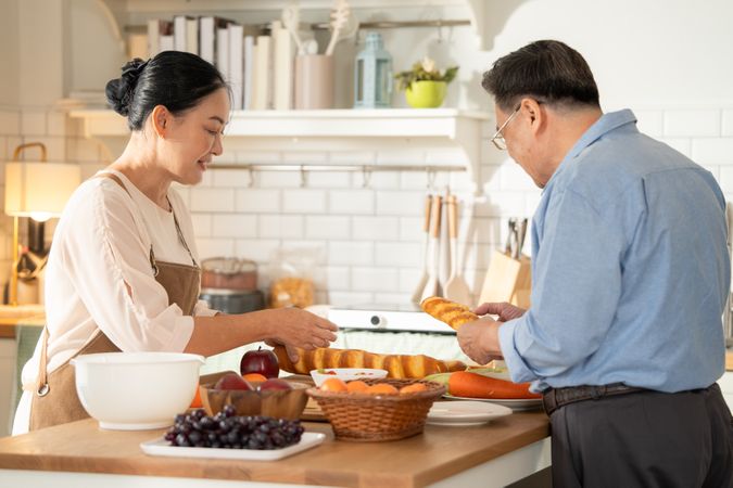 Asian mature couple cooking breakfast in the kitchen