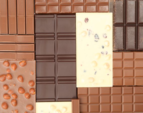 Different chocolate bars on whole background. Top view