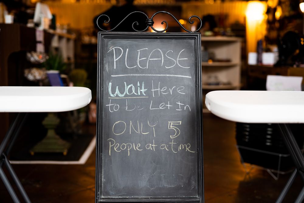 “Please wait” sign to limit customer entrance to retail store