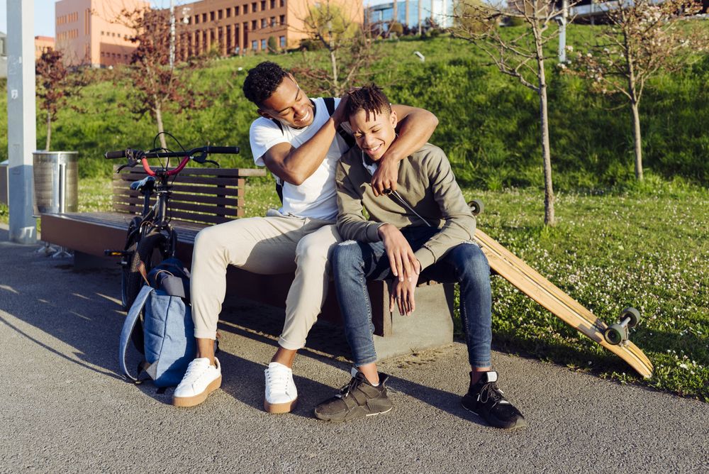 Young Black men playing on street bench