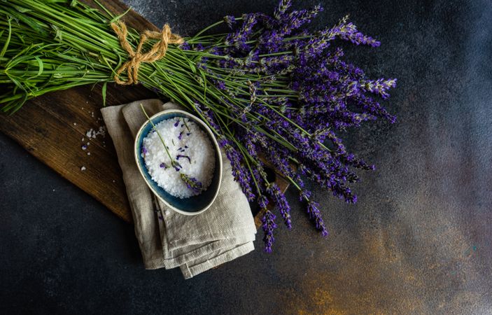 Fresh lavender flowers on a wooden kitchen board with salt