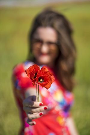 Blurred woman giving flower to camera