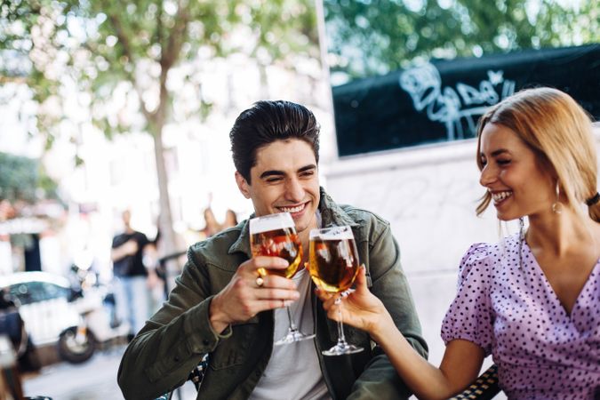 Happy young couple drinking beverages outdoors