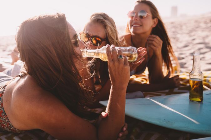 Group of young women drinking beer at the beach