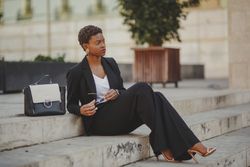 Stylish Black woman with handbag and sunglasses on steps