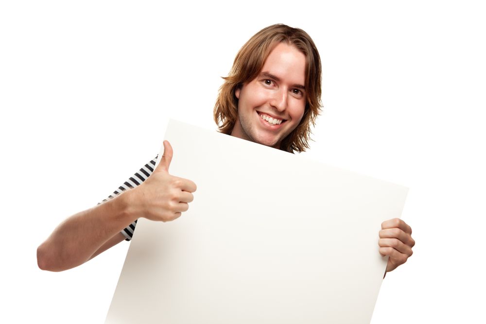 Smiling Young Man with Thumbs Up Holding Blank Sign