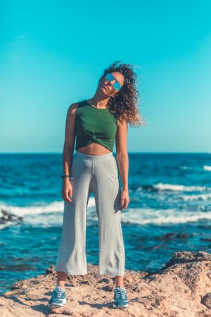 Stylish woman standing near sea
