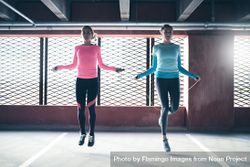 Two woman skipping rope in front of window 5lkj60