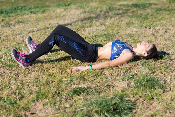 Fit woman stretching after workout in the grass