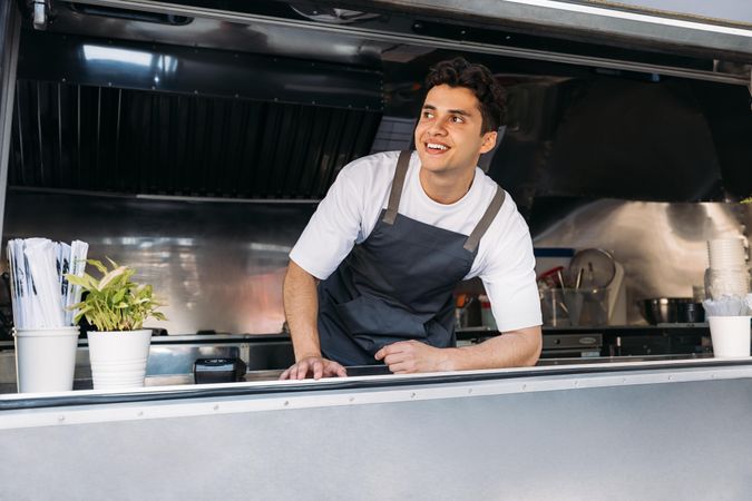 Happy male food truck vendor in open kitchen