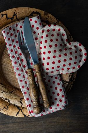 Valentine's day card concept of dotted napkin and heart decoration on rustic plate setting