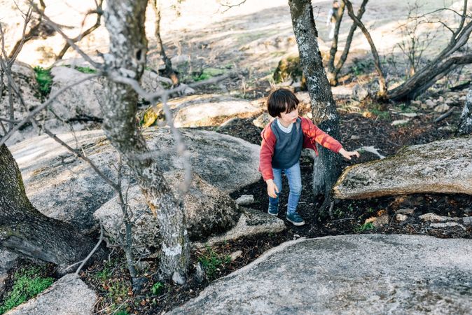 Little boy walking on rocky hill